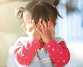 Petite fille qui a peur et se cache les yeux.