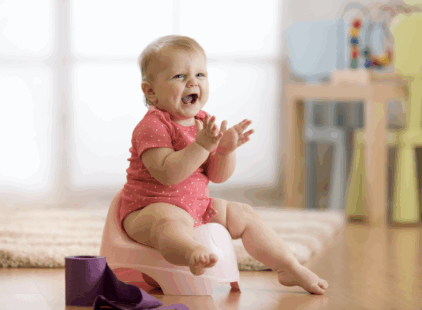 Bébé sur le pot. Il est joyeux et frappe des mains.