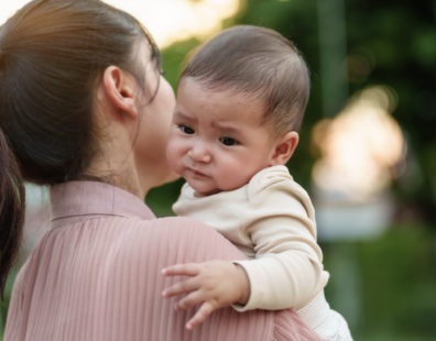 Bébé appeuré dans les bras de maman.