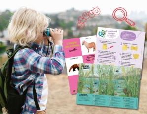 Un enfant explore son environnement avec des jumelles, entouré de pages de jeux sur la nature : imagier des animaux, activité de création et cherche-et-trouve en plein air.
