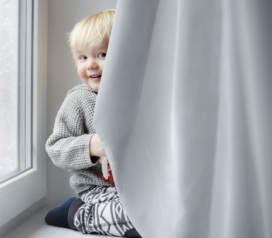 Bébé se cache derrière un rideau