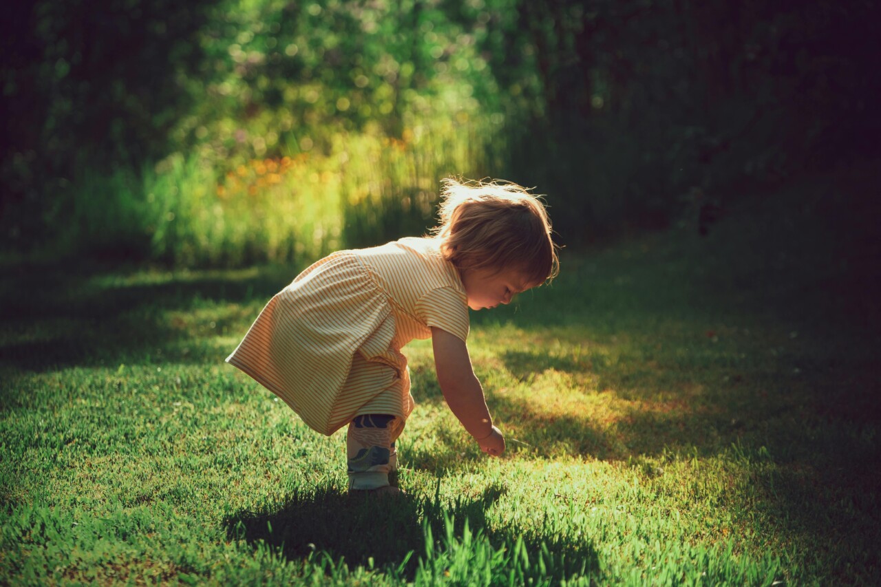 Petite fille qui joue dans l'herbe