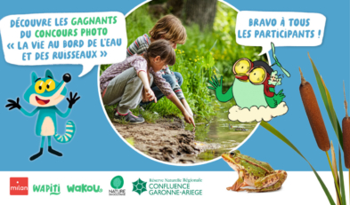 Deux enfants accroupis au bord d'un cours d'eau montrent quelque chose du doigt.